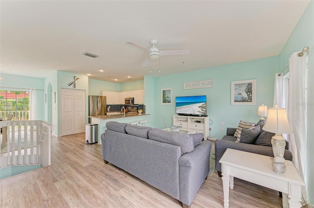 living area featuring visible vents, light wood-style flooring, and ceiling fan