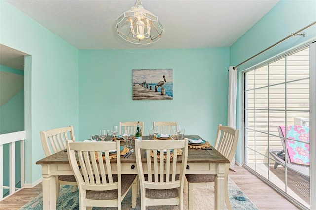 dining area with baseboards, a notable chandelier, and wood finished floors