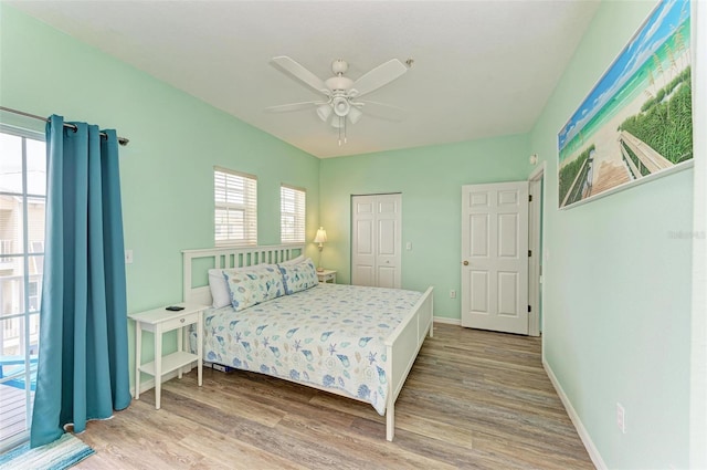 bedroom with wood finished floors, baseboards, a closet, and ceiling fan