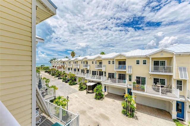 view of property with central air condition unit, a residential view, driveway, and a garage