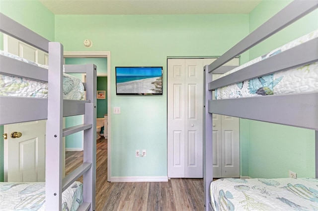 bedroom with a closet, baseboards, and wood finished floors