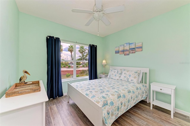 bedroom with ceiling fan, baseboards, and wood finished floors