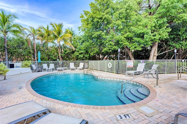 pool with a patio and fence