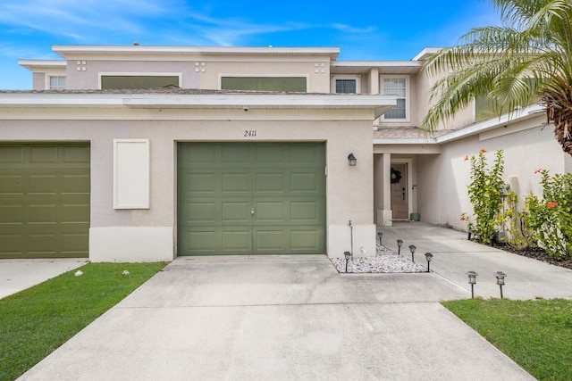 view of front facade featuring stucco siding, a garage, and concrete driveway