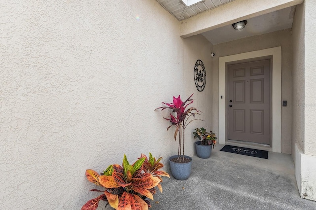 entrance to property featuring stucco siding