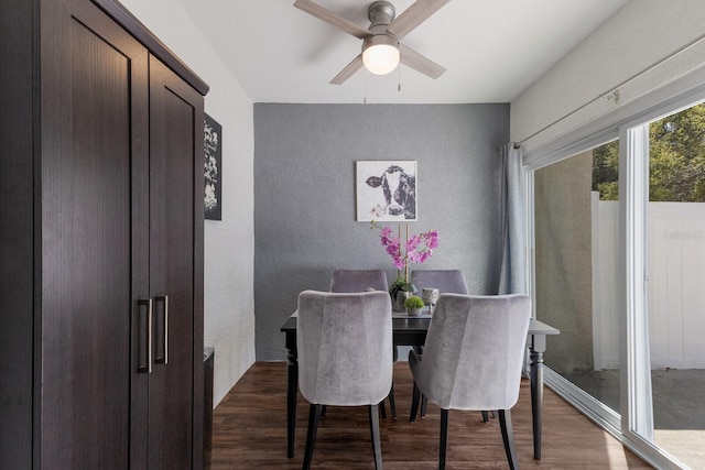 dining area with a ceiling fan, wood finished floors, and a textured wall