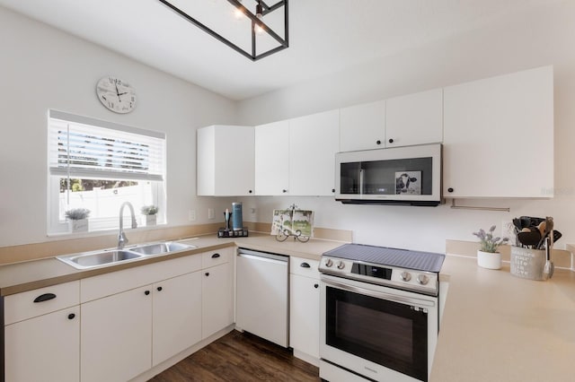 kitchen featuring stainless steel electric range oven, white microwave, a sink, light countertops, and dishwasher