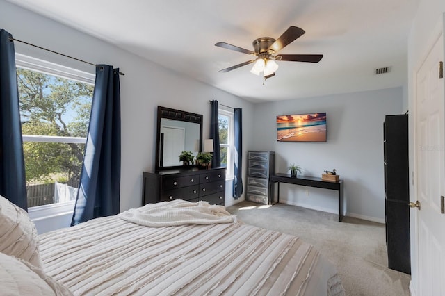 carpeted bedroom with visible vents, baseboards, and ceiling fan