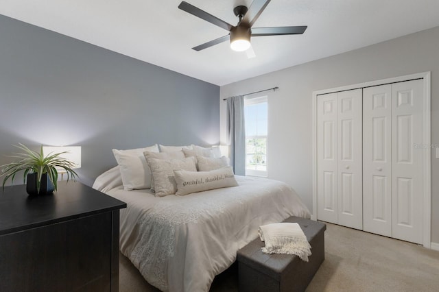 bedroom featuring a closet, light colored carpet, and ceiling fan