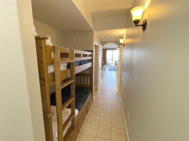 13415 Blue Heron Beach Dr Unit 1407, Orlando, FL 32821 - hall featuring arched walkways, baseboards, and light tile patterned flooring