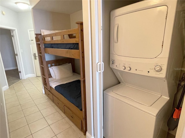 13415 Blue Heron Beach Dr Unit 1407, Orlando, FL 32821 - laundry area with light tile patterned floors, stacked washer / drying machine, baseboards, and laundry area