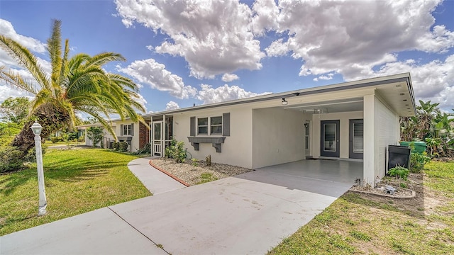 22201 Olean Blvd, Port Charlotte, FL 33952 - ranch-style house featuring stucco siding, a front yard, driveway, and a carport