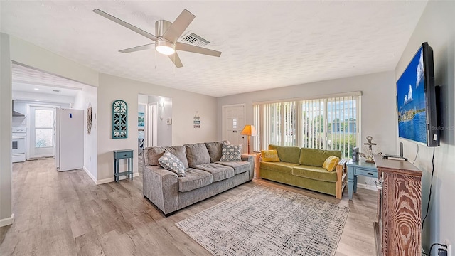 22201 Olean Blvd, Port Charlotte, FL 33952 - living room with a textured ceiling, visible vents, baseboards, ceiling fan, and light wood-type flooring