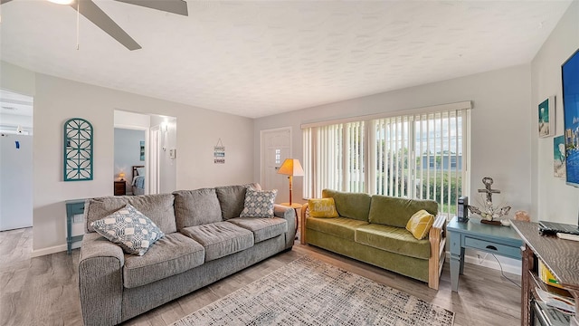 22201 Olean Blvd, Port Charlotte, FL 33952 - living room featuring a textured ceiling, ceiling fan, baseboards, and light wood-type flooring