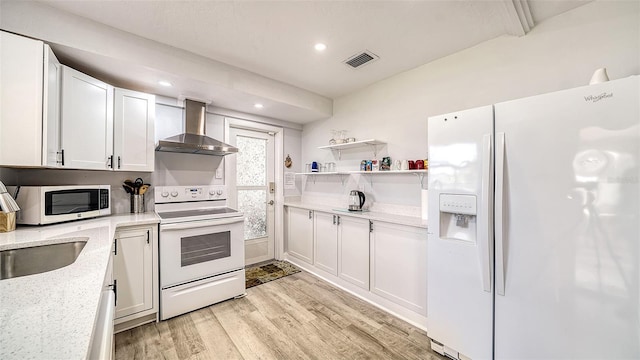 22201 Olean Blvd, Port Charlotte, FL 33952 - kitchen with light wood-type flooring, white appliances, visible vents, white cabinets, and wall chimney exhaust hood