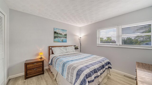 22201 Olean Blvd, Port Charlotte, FL 33952 - bedroom featuring baseboards, light wood-style flooring, and a textured ceiling