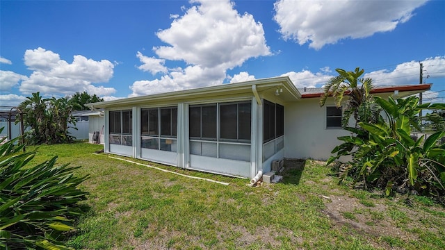 22201 Olean Blvd, Port Charlotte, FL 33952 - rear view of property with a sunroom, stucco siding, and a yard