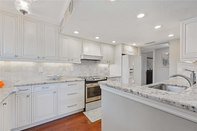 kitchen with custom range hood, a sink, white refrigerator with ice dispenser, stainless steel electric range, and dark wood-style flooring