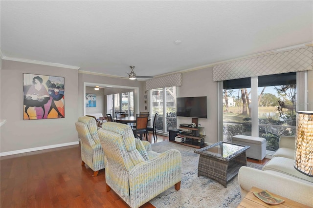 living area with baseboards, wood finished floors, a ceiling fan, and ornamental molding