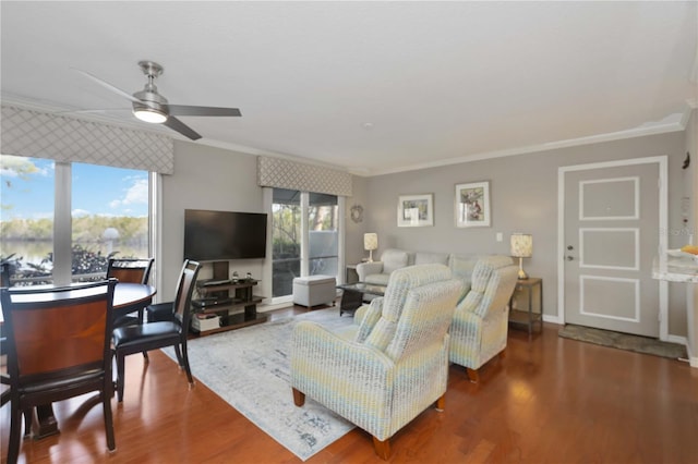 living area with wood finished floors, baseboards, a wealth of natural light, and ornamental molding