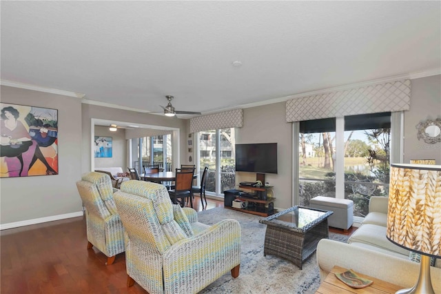 living area featuring a wealth of natural light, baseboards, wood finished floors, and ornamental molding