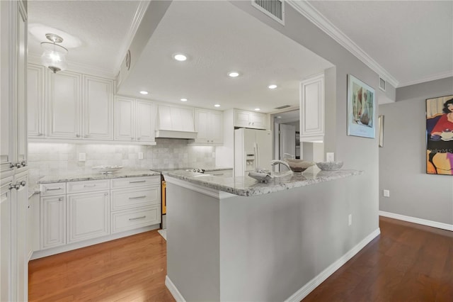 kitchen with visible vents, custom range hood, white fridge with ice dispenser, white cabinets, and light wood finished floors