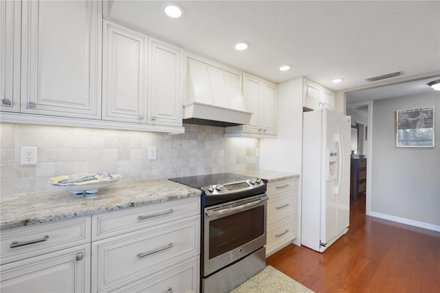 kitchen with visible vents, custom range hood, stainless steel electric stove, white fridge with ice dispenser, and dark wood-style flooring