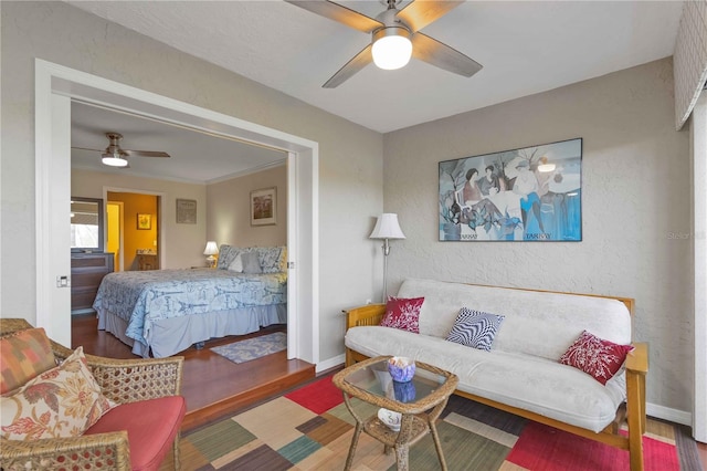 bedroom featuring ceiling fan, baseboards, and wood finished floors