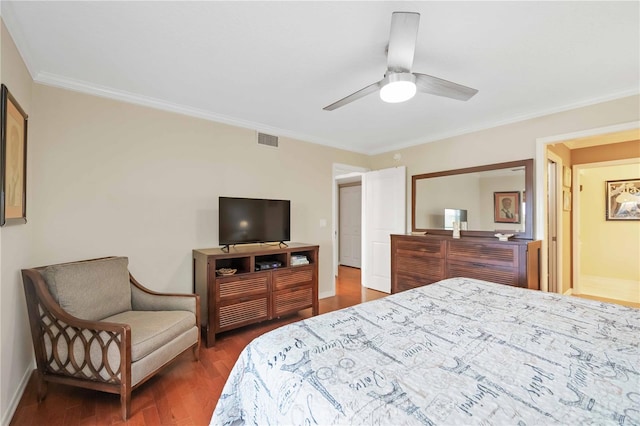 bedroom featuring visible vents, baseboards, wood finished floors, and crown molding