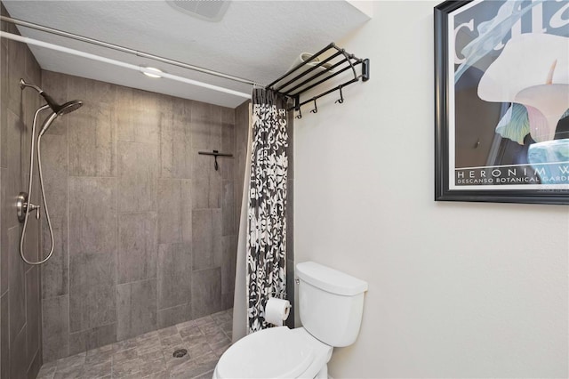 bathroom featuring visible vents, toilet, and a tile shower