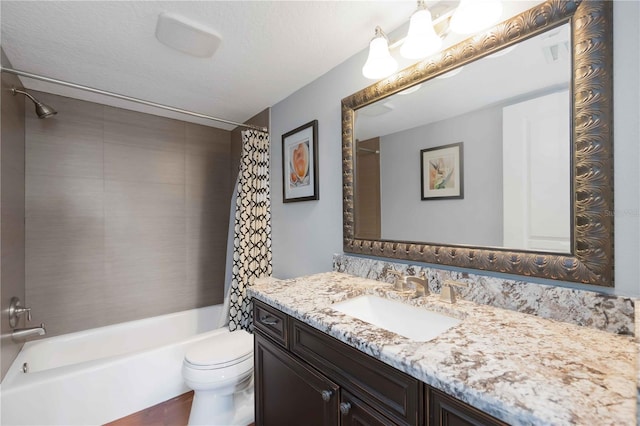 bathroom featuring vanity, toilet, shower / tub combo with curtain, and a textured ceiling