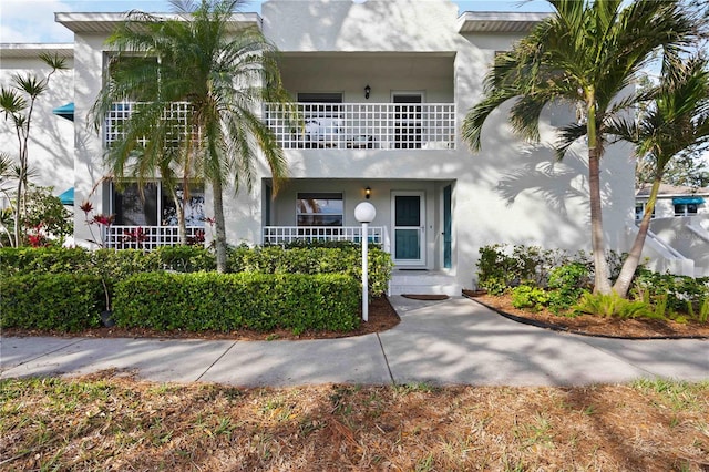 view of front of house with a balcony and stucco siding