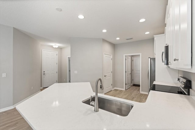 5998 Amberly Dr, Bradenton, FL 34208 - kitchen with light wood-type flooring, a sink, white cabinetry, recessed lighting, and appliances with stainless steel finishes