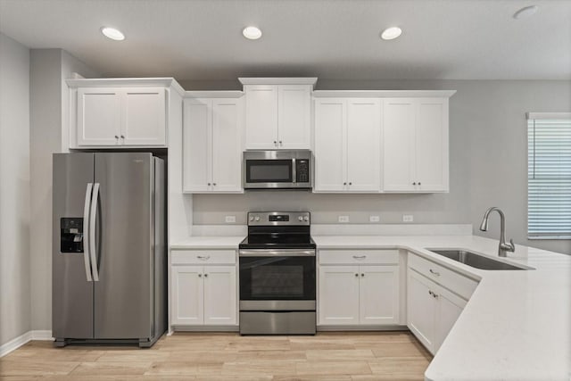 5998 Amberly Dr, Bradenton, FL 34208 - kitchen featuring light countertops, appliances with stainless steel finishes, a peninsula, white cabinets, and a sink