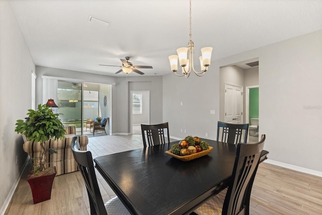 5998 Amberly Dr, Bradenton, FL 34208 - dining area with visible vents, baseboards, light wood-style flooring, and ceiling fan with notable chandelier