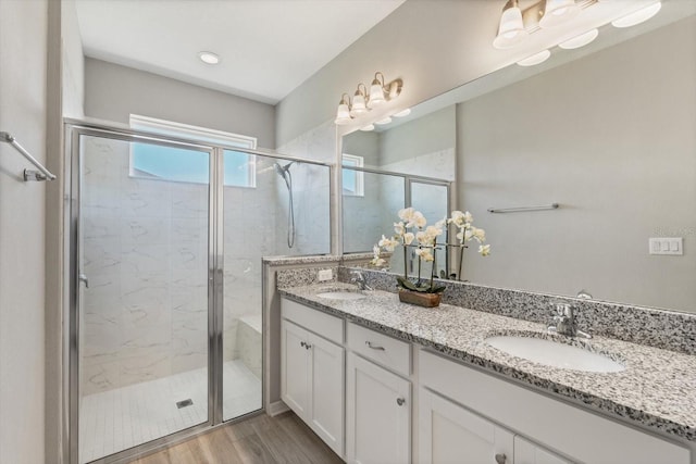 5998 Amberly Dr, Bradenton, FL 34208 - full bathroom featuring double vanity, wood finished floors, a stall shower, and a sink