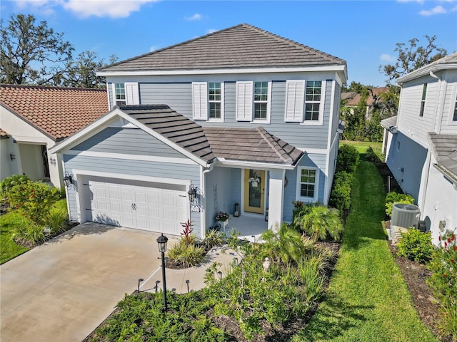 traditional-style home featuring central AC, concrete driveway, an attached garage, and a tiled roof