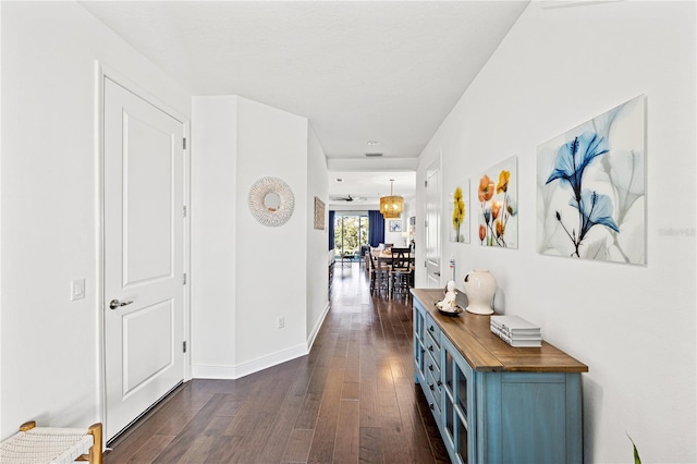 hallway with dark wood-style floors and baseboards