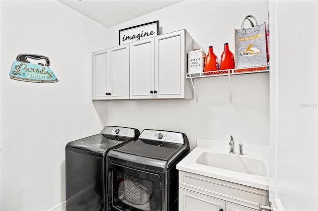 clothes washing area featuring cabinet space, separate washer and dryer, baseboards, and a sink