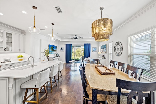 dining space with visible vents, crown molding, recessed lighting, ceiling fan with notable chandelier, and dark wood-style flooring