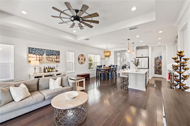 living room featuring visible vents, dark wood finished floors, a tray ceiling, recessed lighting, and ceiling fan