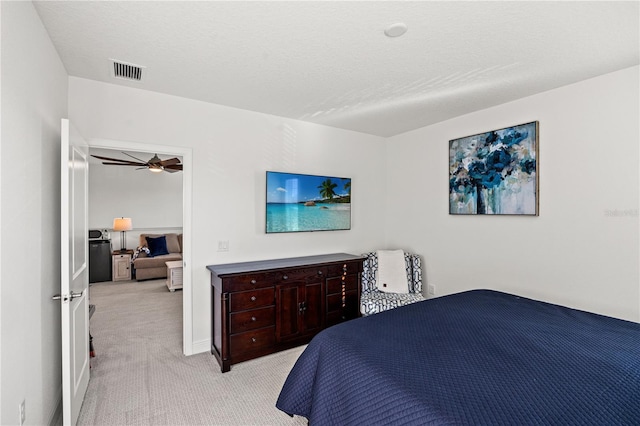 bedroom featuring carpet, visible vents, and a textured ceiling