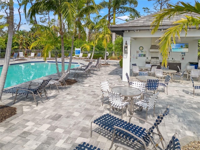 pool with a grill, a patio, and fence