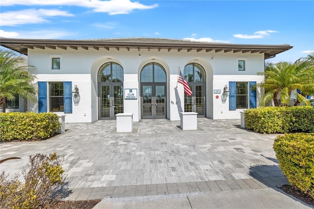 rear view of property with french doors and stucco siding