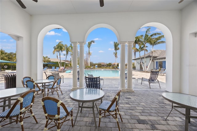 view of patio with a ceiling fan and a community pool