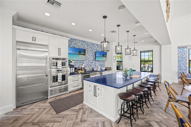 kitchen featuring a warming drawer, visible vents, a spacious island, and appliances with stainless steel finishes