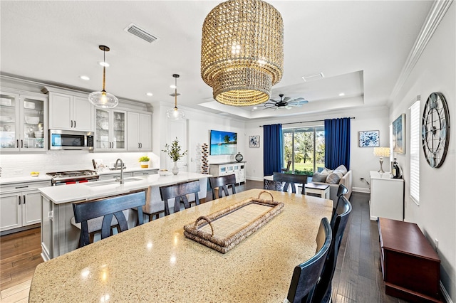 dining space featuring visible vents, a raised ceiling, ornamental molding, and recessed lighting