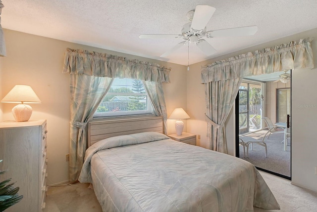 bedroom with a textured ceiling, access to exterior, multiple windows, and light carpet