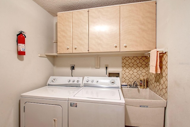 laundry area with washer and dryer, cabinet space, and a sink