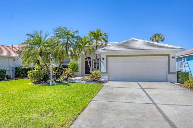 view of front of house with a front yard, an attached garage, stucco siding, concrete driveway, and a tiled roof